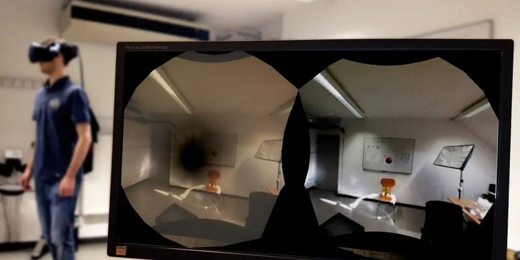 A person wearing en HTC Vive pro standing in the background on the left and a PC screen in the foreground showing the AR view of a person with posterior supcapsular cataracts simulated for the left eye and the unmodified video-see through stream for the right eye.